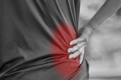 Close up of a man holding his back in pain