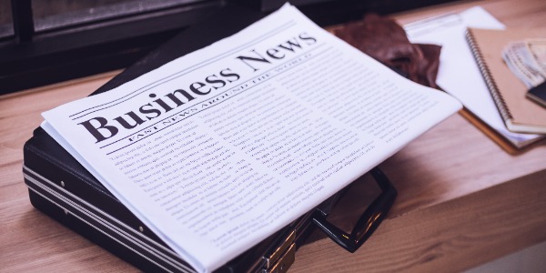 newspaper-briefcase-on-a-wooden-table-in-the-cafe