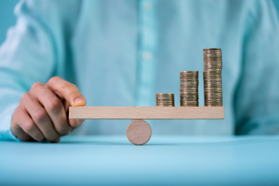 person balancing coins on office desk toy