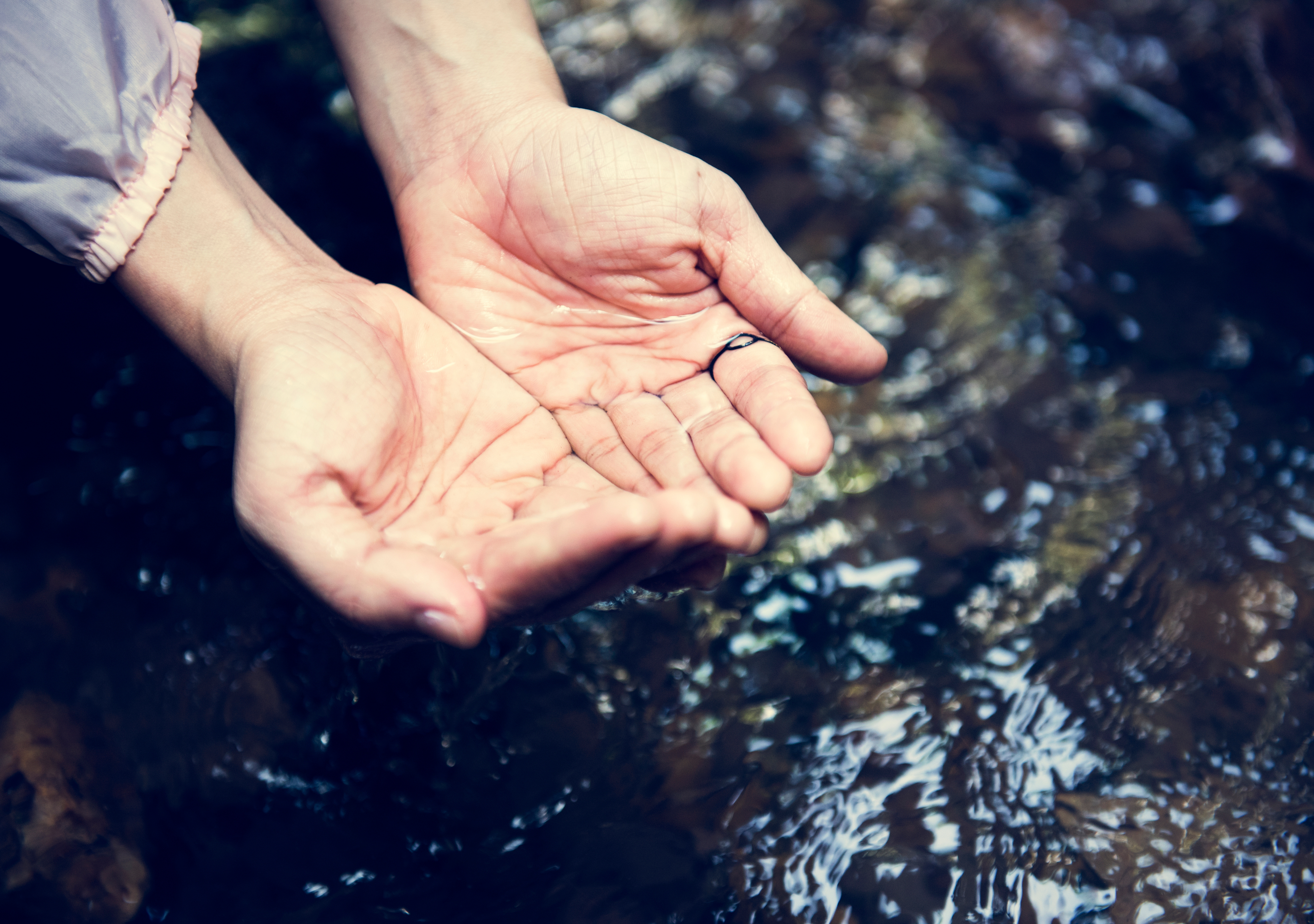 Delicate hands cradle shimmering water