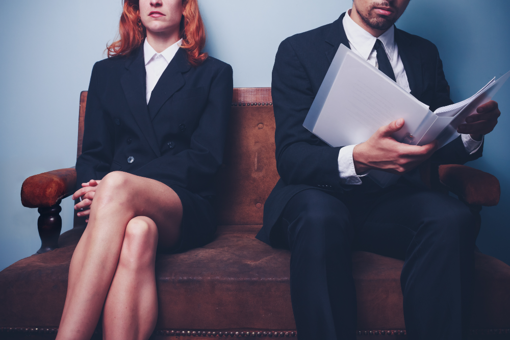 man and woman in suits, sitting on a bench