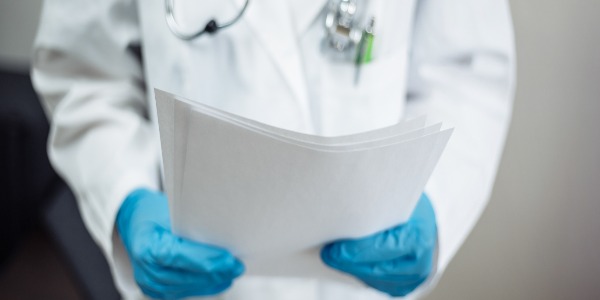 closeup-of-a-woman-doctor-wearing-white-medical-gown-and-blue-gloves-stethoscope-female-nurse