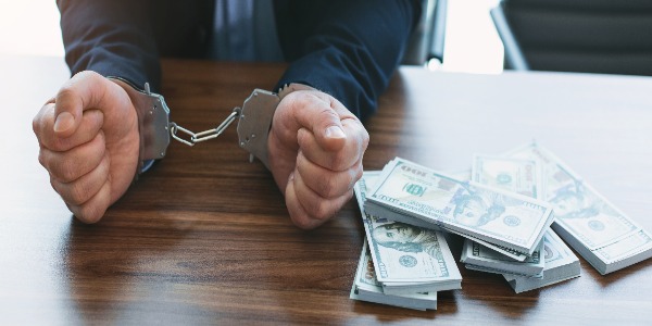 accusation-rich-high-ranking-official-wearing-handcuffs-and-money-lying-near-him