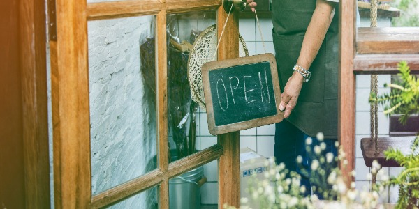 man-flip-the-open-banner-of-cafe-at-the-door