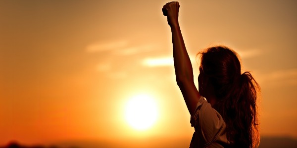 silhouette-of-a-woman-with-raised-arms-power-and-victory